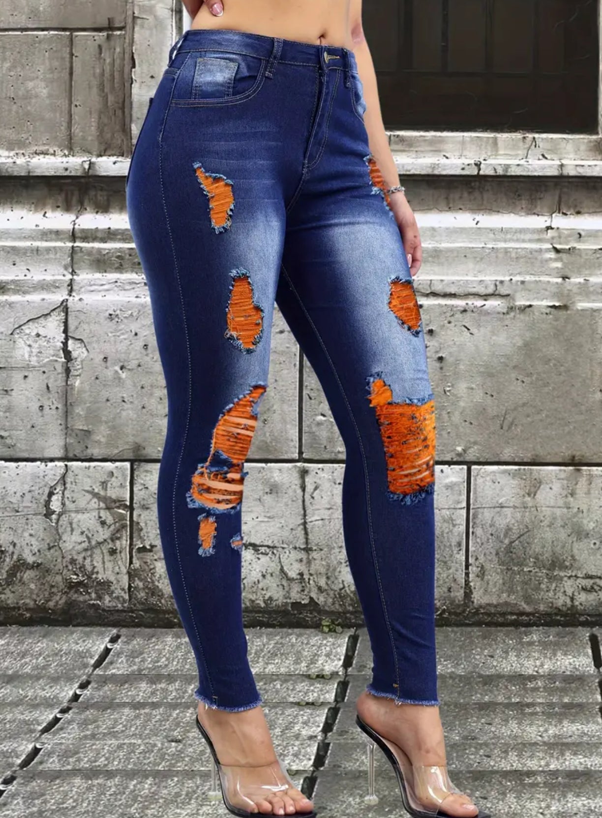 Vaqueros pitillo desgastados y elegantes de color naranja neón: denim elástico con detalles rasgados a la moda