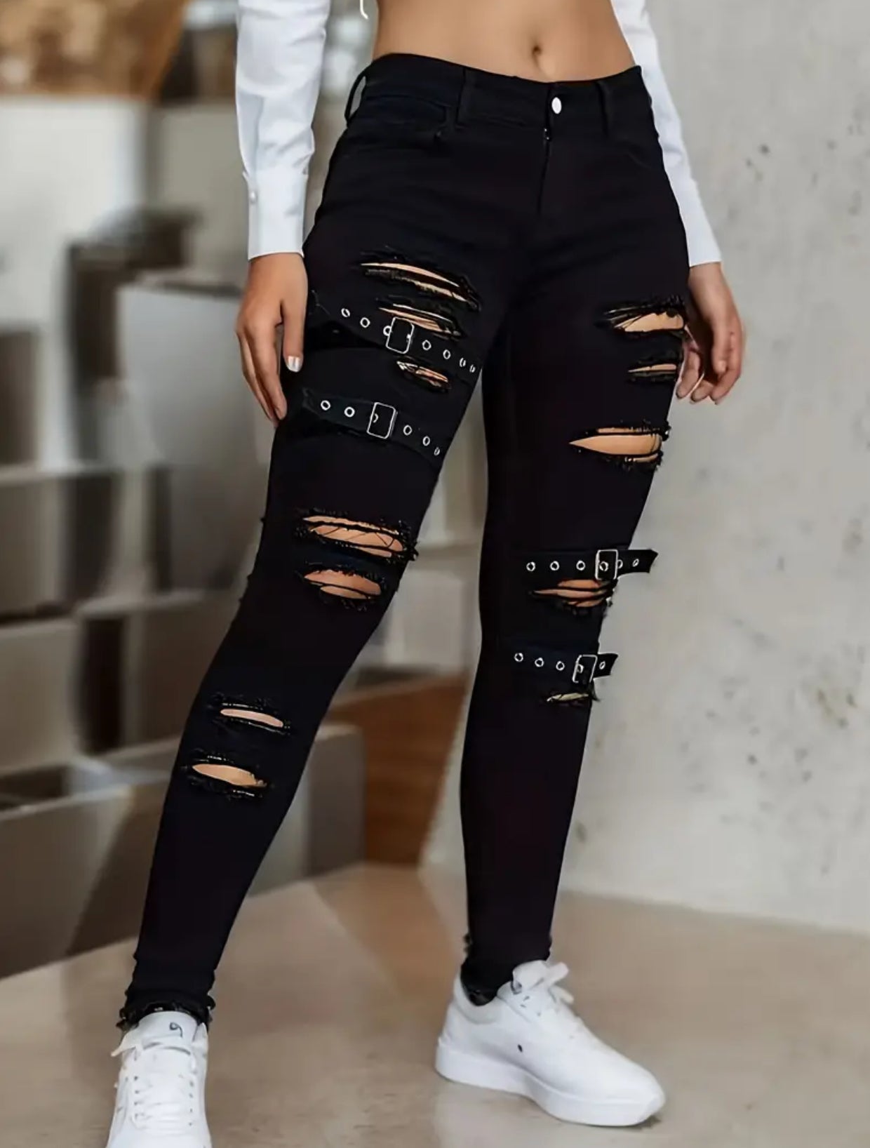 Jeans desgastados y rotos de color negro con detalles de hebillas, cintura alta, estilo callejero, pitillos